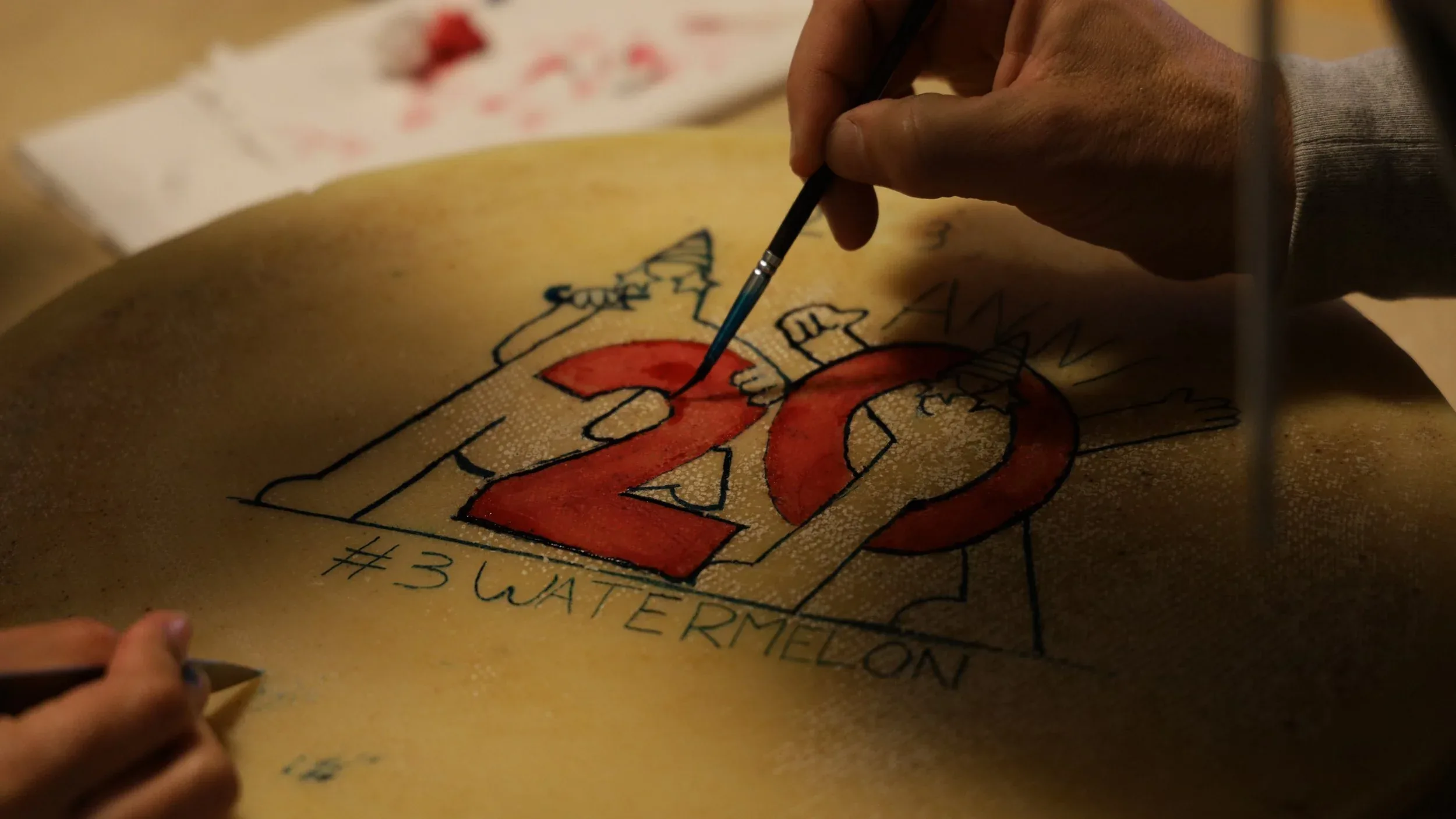 The team's hands painting the wheel of Storico Ribelle cheese for Watermelon's twentieth anniversary, in Gerola